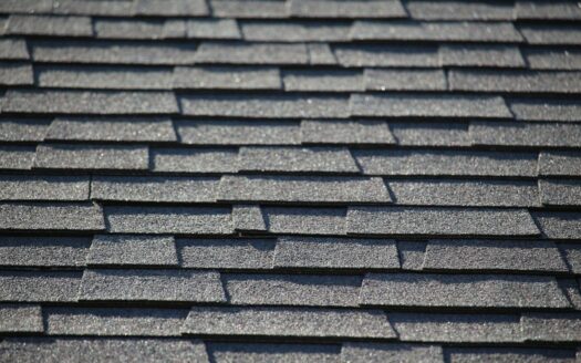 Close-up of gray architectural asphalt shingles on a pitched house roof